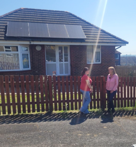 Leigh, a tenant in Hoyland, and Julia Davies, a philanthropic investor, standing outside Leigh’s home which has solar panels on the roof. 