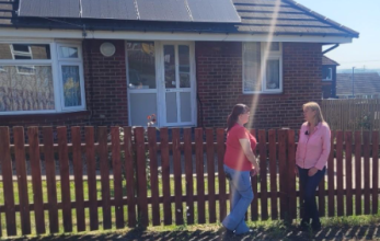 Leigh, a tenant in Hoyland, and Julia Davies, a philanthropic investor, standing outside Leigh’s home which has solar panels on the roof. 