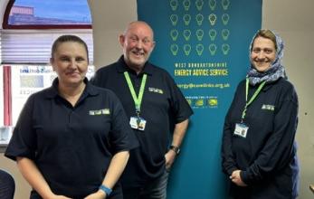 West Dunbartonshire Energy Advice team standing together in front of a pull-up banner.