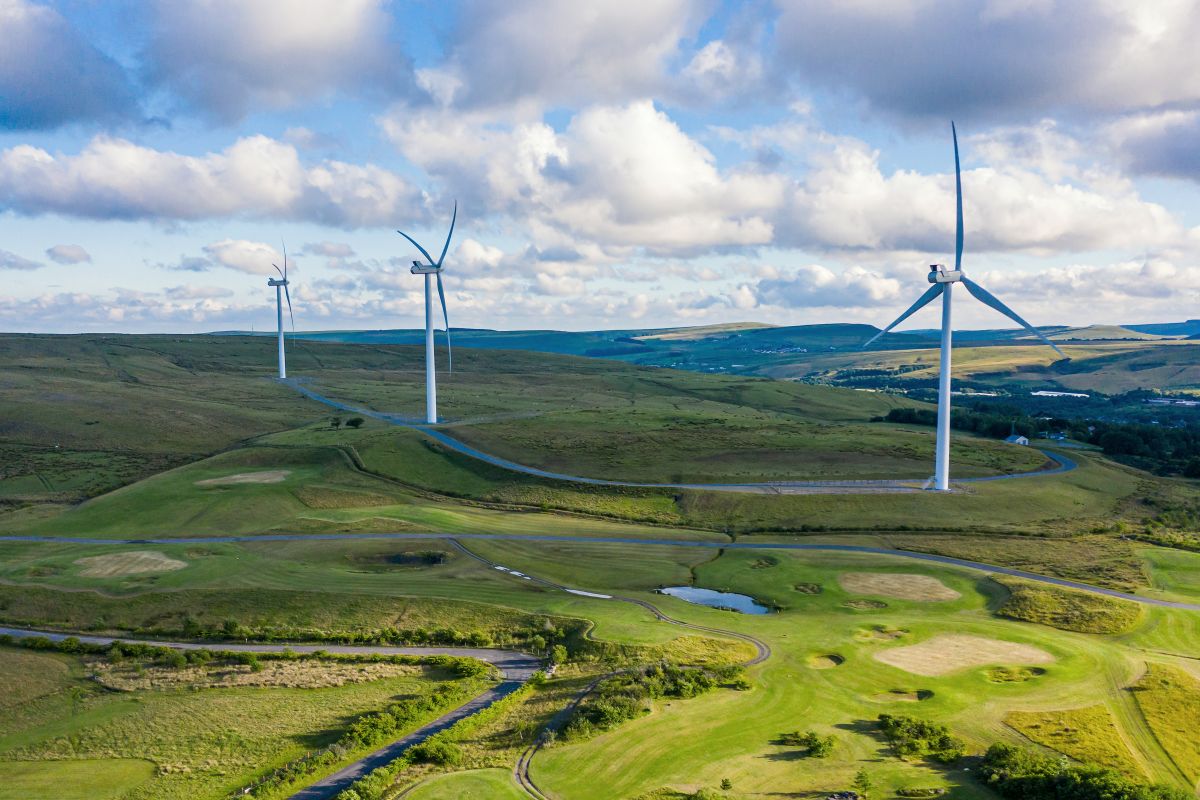 aerial drone shot of several clean energy wind turbines in a rural area of Wales